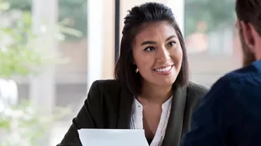 Two people having a conversation in an office setting.